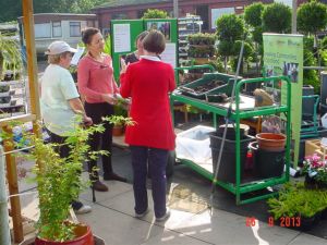 During an information session at a garden center (Growforth Fife), Fiona Thackeray (in the pink shirt) explains gardening techniques adapted to people with health conditions such as arthritis and multiple sclerosis.